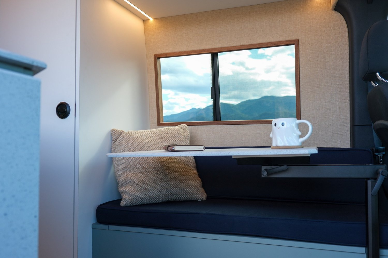 Verde seating area with a small table and mountain-view window