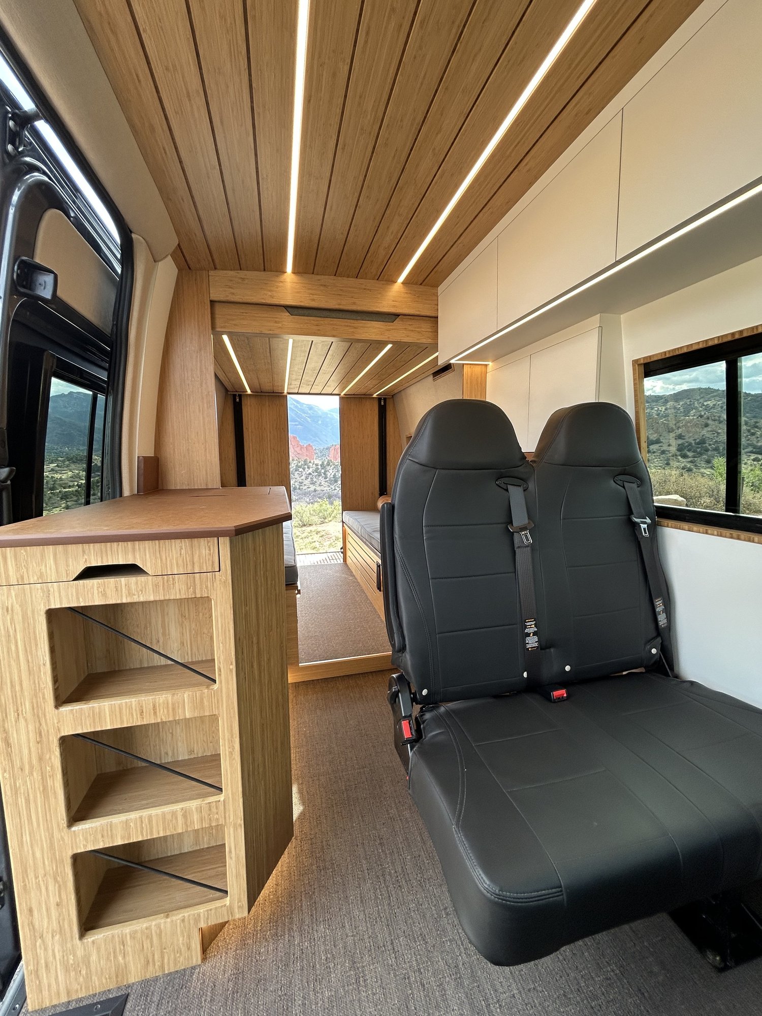 Looking into The Den, with wood cabinetry, passenger seating, and the rear living space