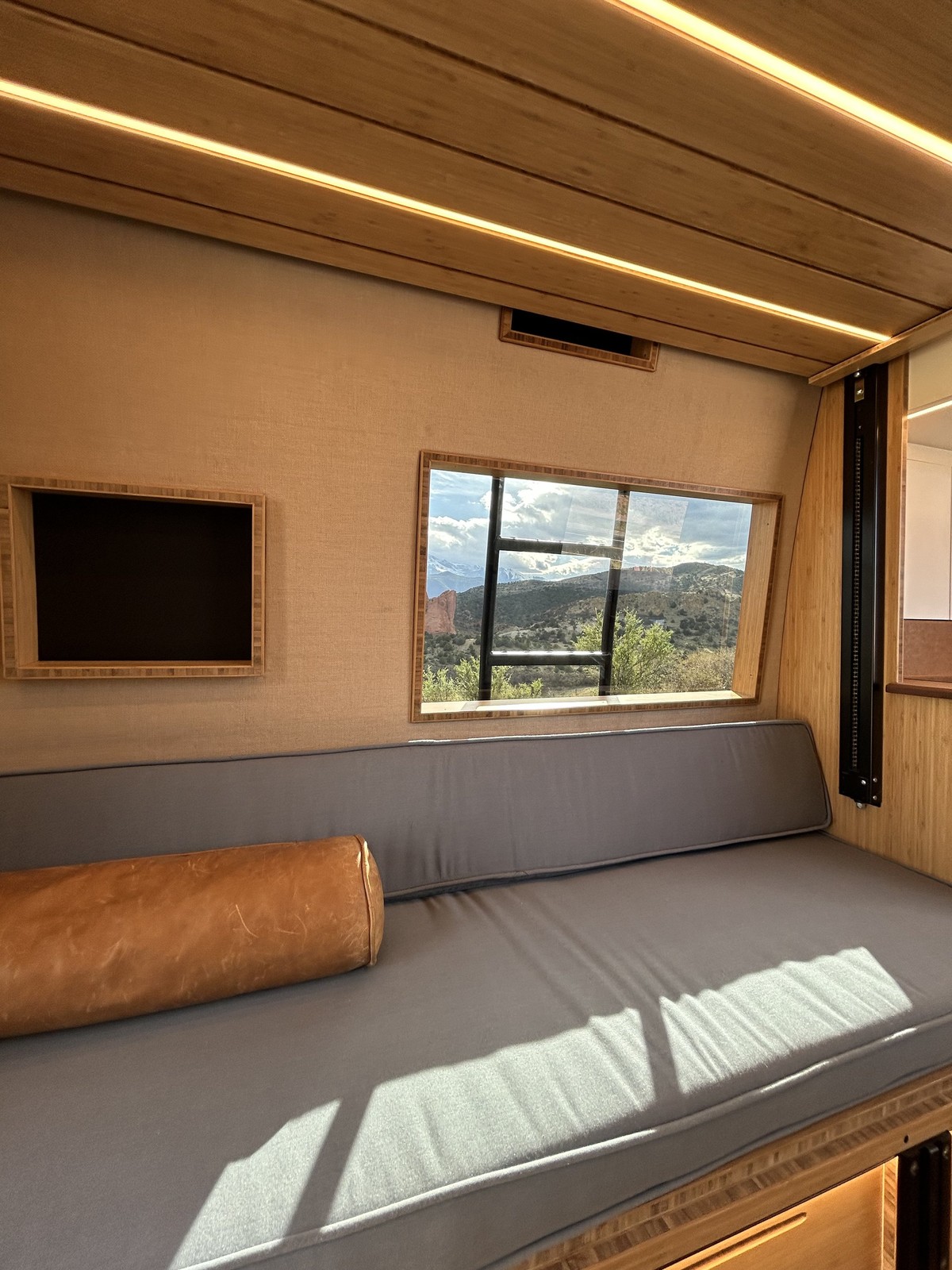The Den lounge bench beneath a window, small wall cubby and elevator-bed platform.