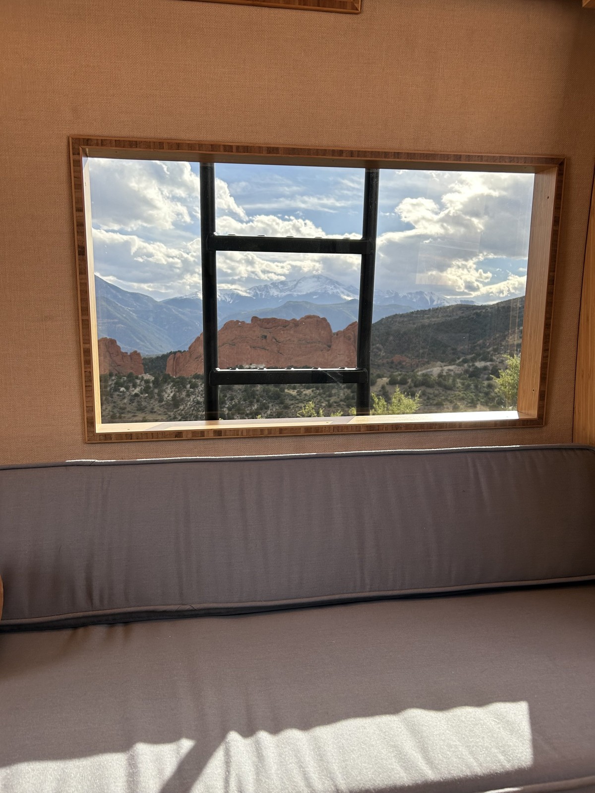 The Den lounge cushion beneath a window framing a mountain view.