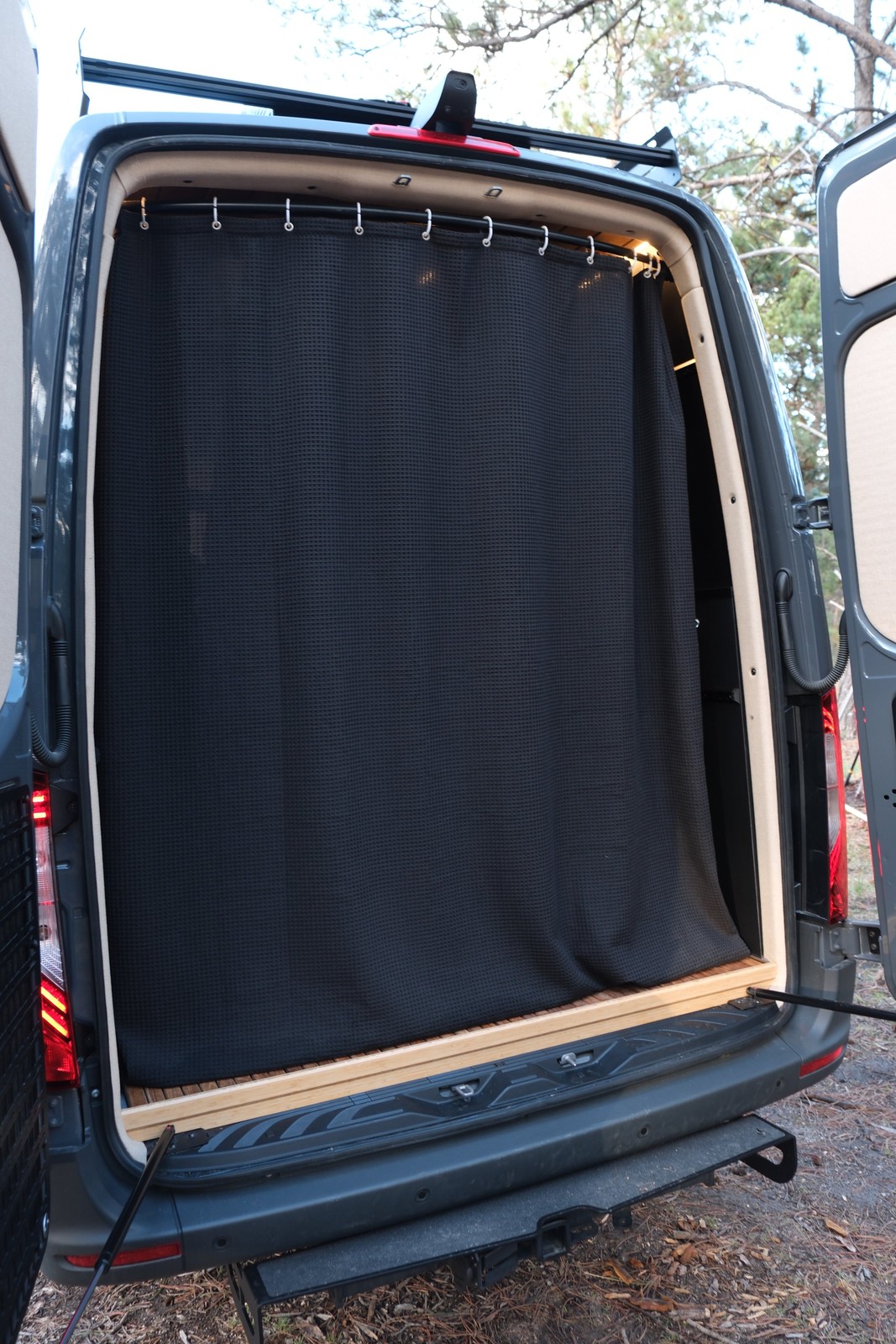 The Den rear opening with a black privacy curtain closed across the wet bath.