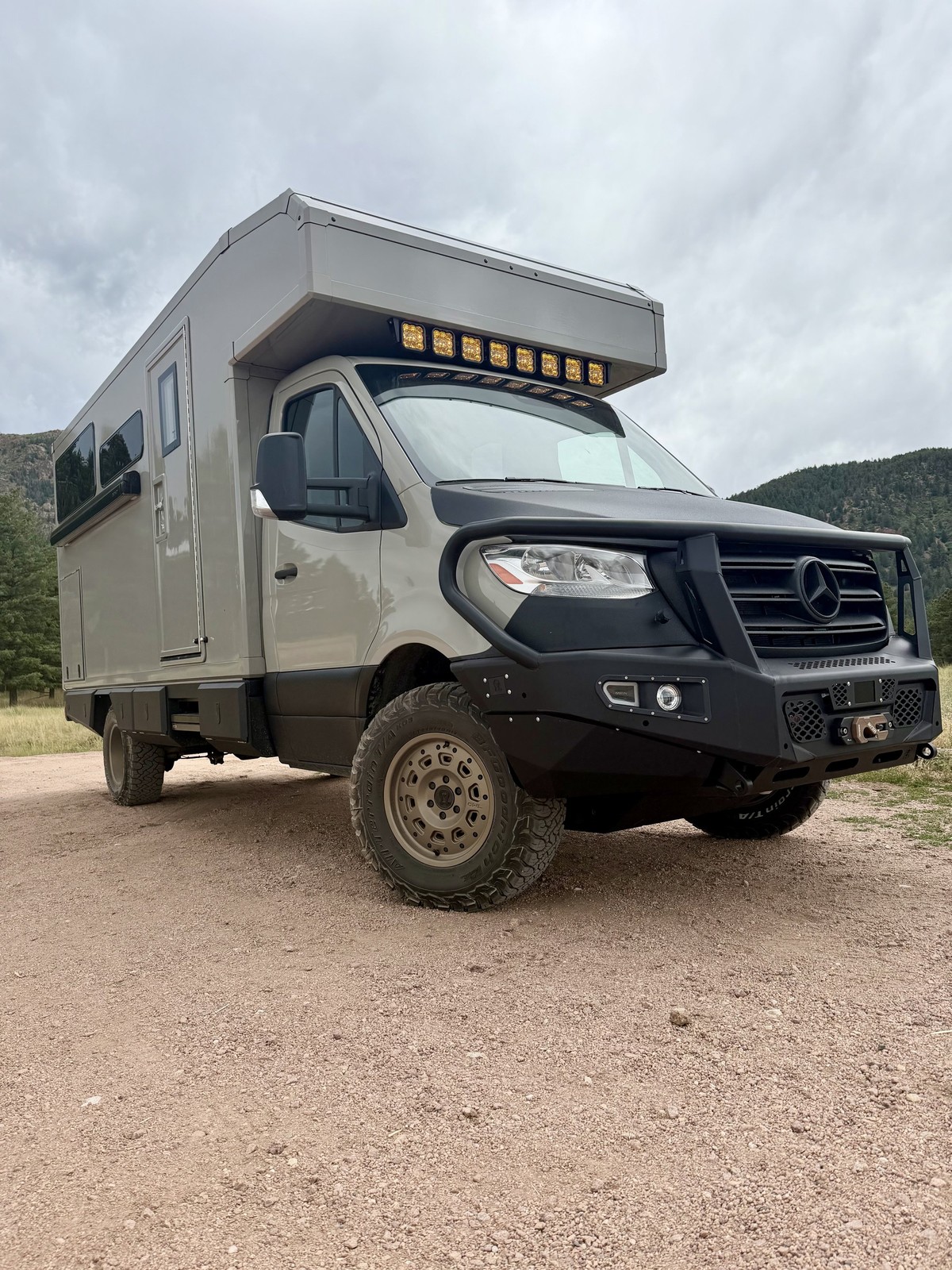 Front three-quarter view of the Nest adventure vehicle parked on a gravel road.