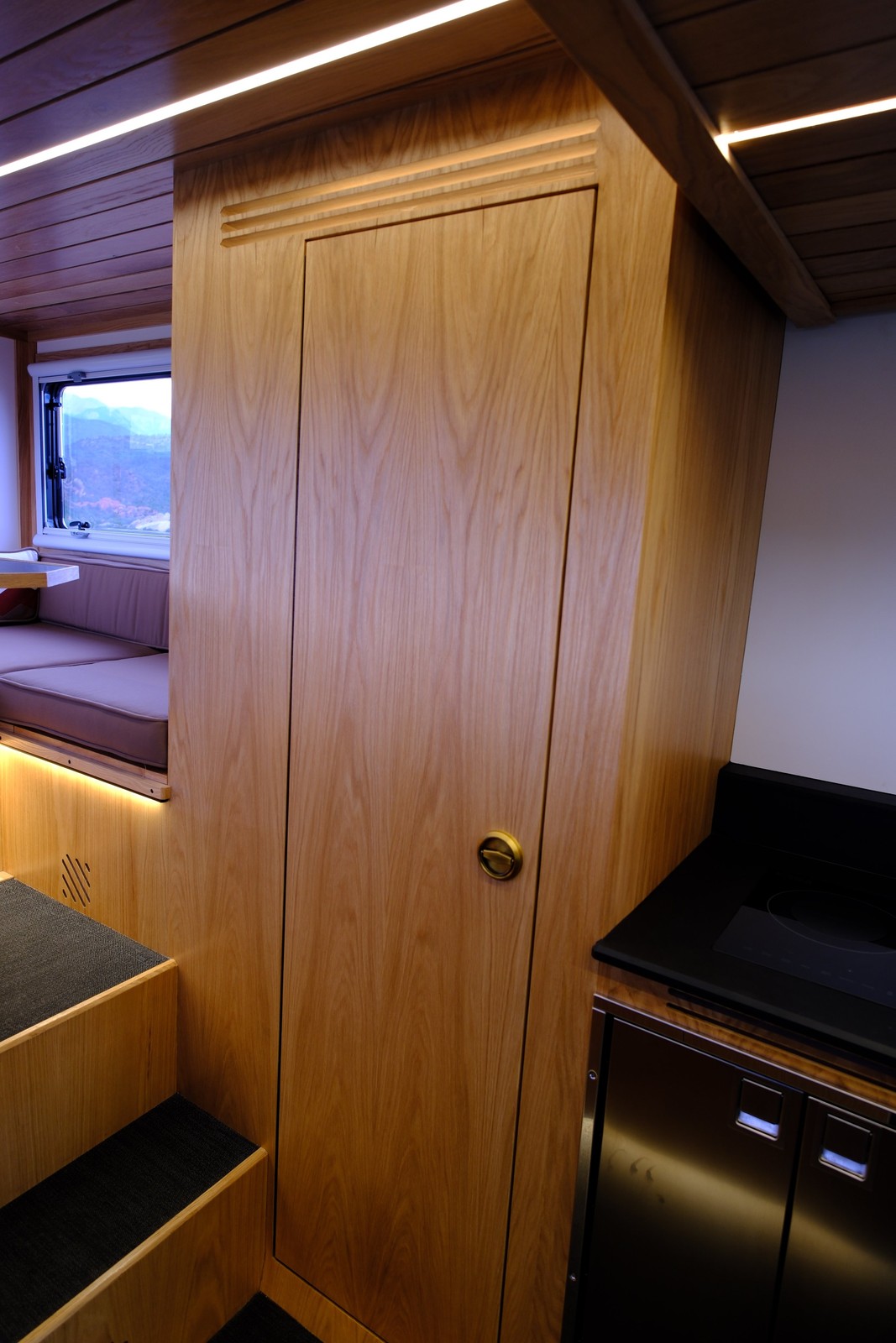 The Nest wood-paneled bathroom door beside the rear dinette steps.